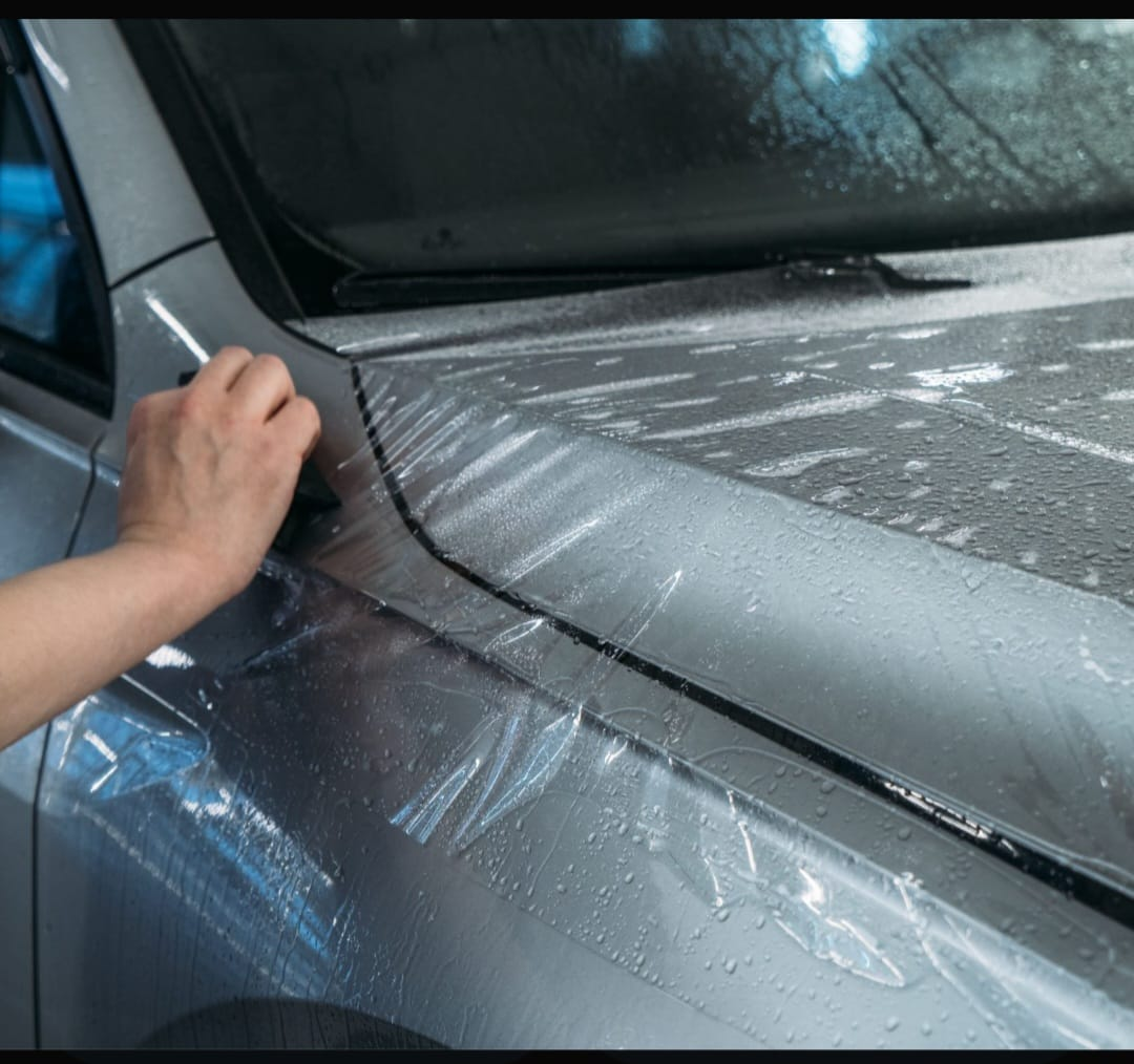 Aplicação de película PPF transparente no capô de um carro